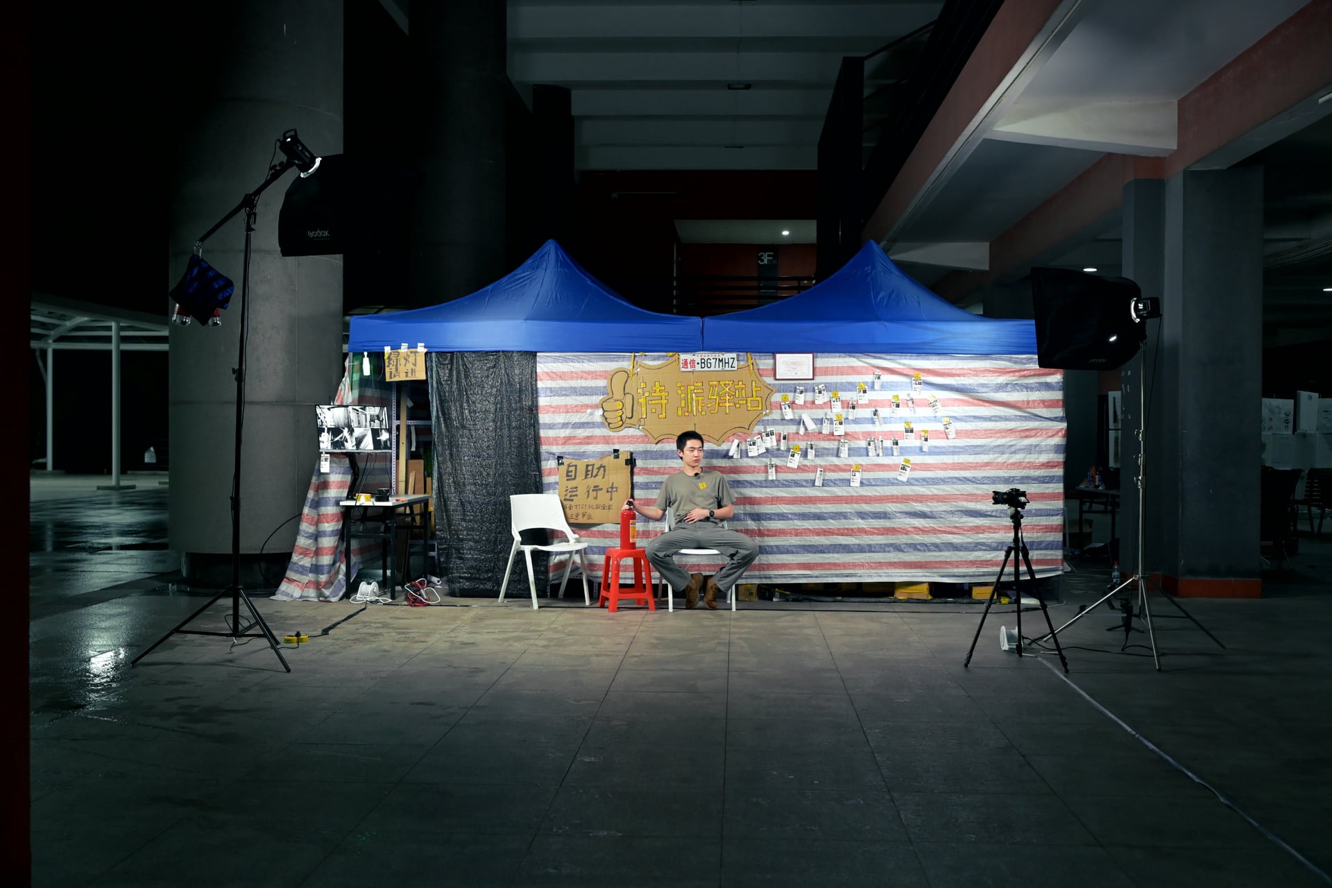 《人件—高仿驿站》夜间展场全景，帐篷、灯光、机位与体验者共同构成现场